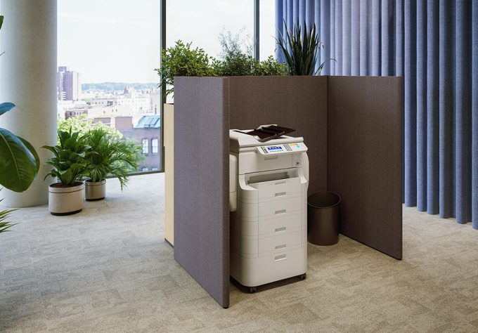 Modern acoustic printing station with a printer, a dark brown enclosure, a black round trash can, and potted plants.